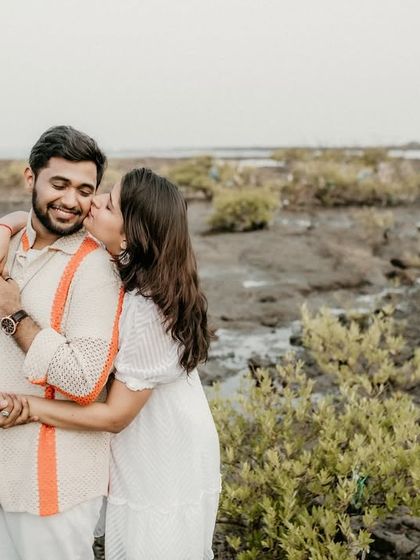 A sweet kiss on the cheek in a unique marshy beach location. This photo shows that beautiful moments can be found in unexpected and rustic settings.