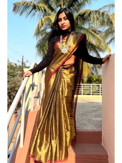 A full-length view of the copper-brown tissue cotton saree. The rich color and lustrous texture make it a true statement piece for any celebration.