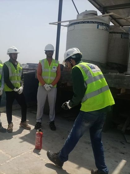 A technician demonstrates the proper stance and technique for using a fire extinguisher. We ensure our teams are well-versed in all aspects of emergency preparedness.