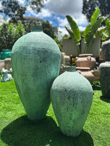 A pair of my ethereal 'Kembung' vases from the GRC range, shown on a bright green lawn that makes their color pop.