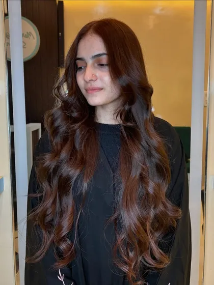 A copper brown global color on very long hair. The result is a stunning, uniform shade that is both warm and elegant.