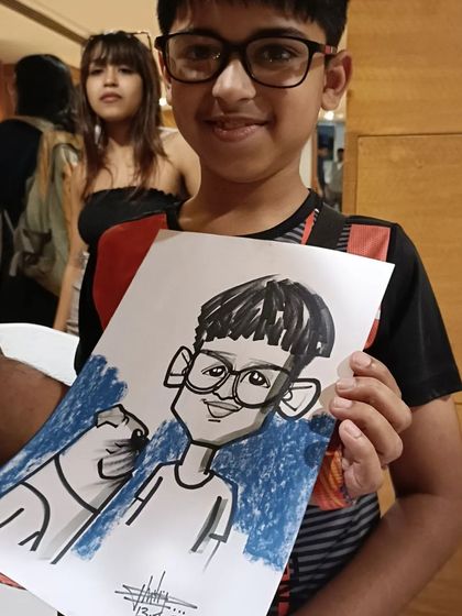 A young boy and his dog, both immortalized in a caricature at a pet-friendly event in Mumbai.