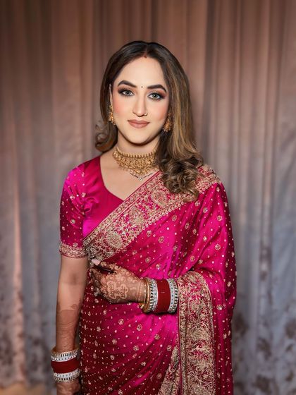 A soft and elegant reception look. The gold-toned eyeshadow and luminous skin pair perfectly with her pink saree, creating a look that's both glamorous and graceful.