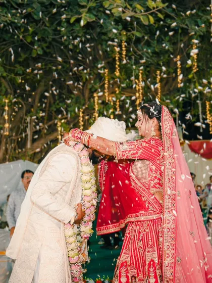 The bride's turn. A joyful shot of the bride placing the garland on the groom during their varmala ceremony.