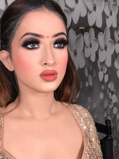This look is all about the eyes. A classic black smokey eye with sharp liner and full lashes, paired with a matte nude-pink lipstick. This is a timeless party look that suits any glamorous occasion.