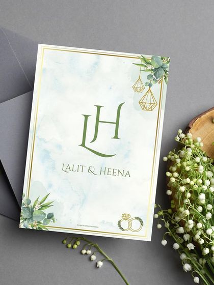 The front of the minimal greenery-themed wedding invitation. The focus is on the couple's custom 'LH' monogram, beautifully framed by watercolor eucalyptus leaves, setting a tone of natural and simple elegance.
