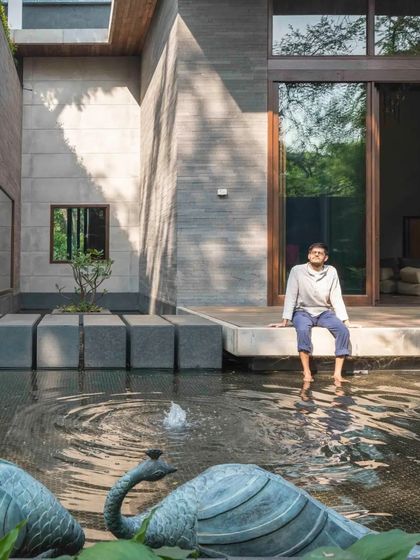 A resident enjoys the tranquility of the water court, a space designed for peaceful reflection and connection with the natural elements.