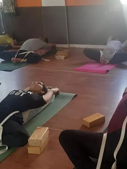 This is a restorative yoga session where we use props like straps and blocks. This approach allows the body to relax completely into a pose, helping to release tension and soothe the nervous system.