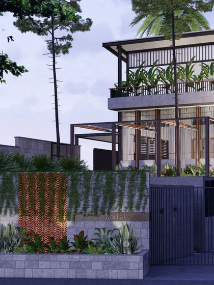 Another view of the Hegde Residence entrance, showcasing the contemporary design that blends metal framework with traditional materials. The house is set back behind a green buffer, creating privacy from the street.