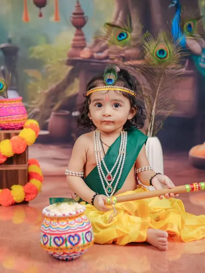 A serene portrait of a baby Krishna, holding his flute against a backdrop of peacocks. I focus on creating a calm environment to capture these peaceful moments.