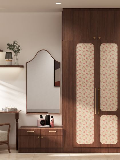 This bedroom nook features a custom wardrobe with fabric-paneled doors, paired with an integrated vanity unit. The design provides ample storage while creating a cozy and personal corner.