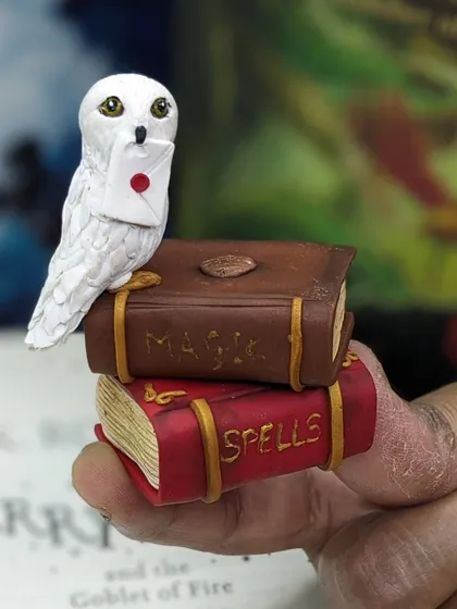 Holding the tiny Hedwig and books miniature. It's amazing how much detail can be packed into such a small piece.