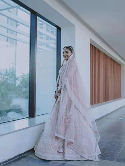 A beautiful portrait of the bride looking out a window, her expression full of anticipation.