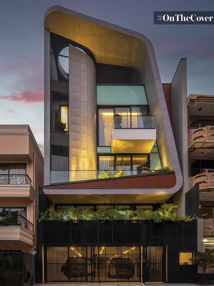 A view of the Luminara residence at dusk, where the sculptural form is highlighted by carefully integrated lighting. The curved roofline and layered volumes create a sense of movement, showcasing a design that is both an architectural statement and a comfortable home.