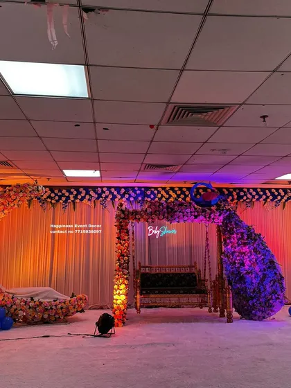 Another view of the grand baby shower stage, highlighting the warm lighting and the balance between the different decorative elements. You can see the floral peacock, the jhula, and the moon cradle ready for the celebration.