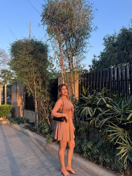 A full-length shot of the sunlit pink dress.