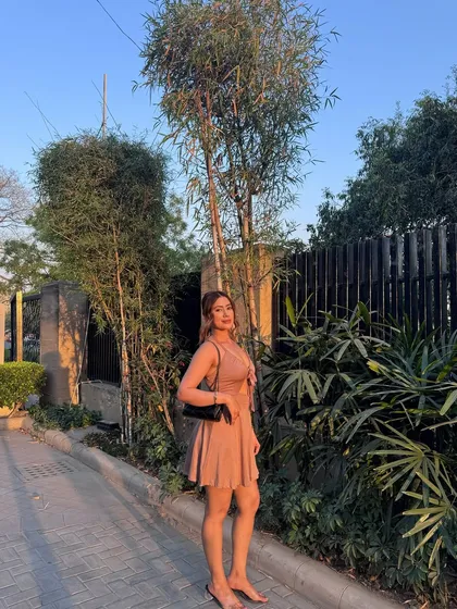 A full-length shot of the sunlit pink dress.