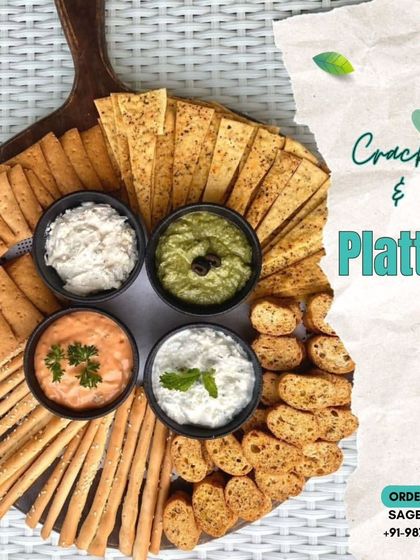 Elevate your snack game with our most-loved crackers and dips platter. This arrangement on a wooden board features four unique dips surrounded by an assortment of crackers and breadsticks.