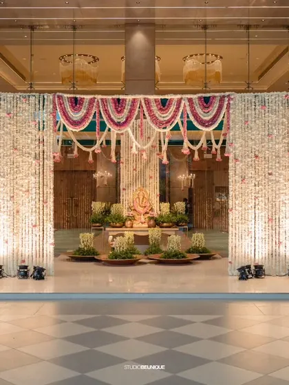 A wide shot of the floral entrance, illuminated to create a dramatic and awe-inspiring welcome for an evening reception.
