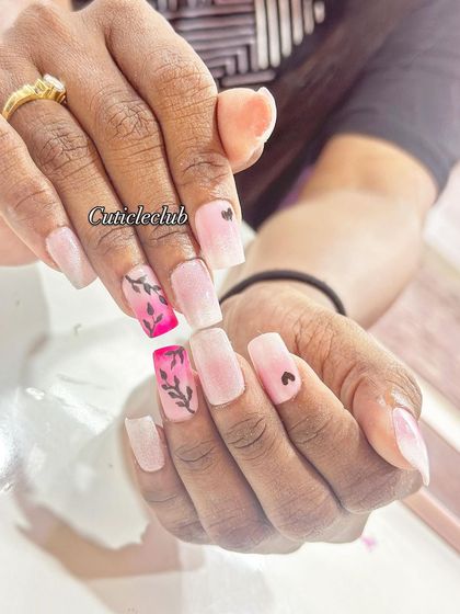 A cute and creative design on square nails, featuring a pink marble effect and hand-painted black leaf silhouettes.