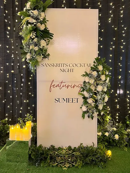 The full view of the welcome sign, framed with elegant white floral arrangements.