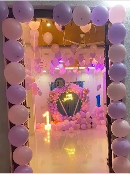 A view from the doorway of a room completely transformed for a first birthday. The purple and pink balloon decor creates an immersive and festive atmosphere from the moment you enter.