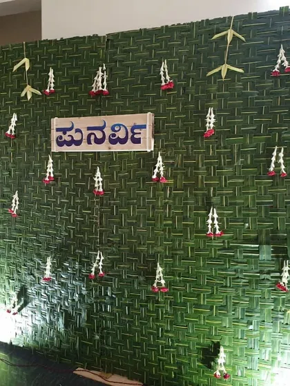 A full view of the traditional naming ceremony backdrop made from woven coconut leaves, with a custom Kannada nameplate.