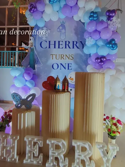 Here you can see the full "Frozen" themed setup, complete with light-up letters for the name 'Cherry' and pedestals for the cake and gifts.