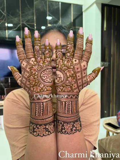 Handcrafted happiness, indeed! This design features personalized initials within a beautiful circular frame, surrounded by intricate patterns that extend down the wrist.