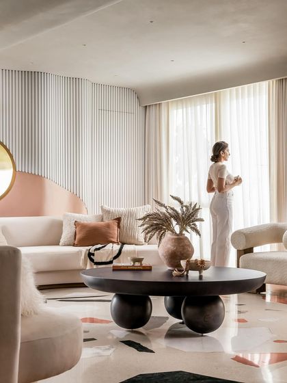 A serene moment in the living room, where a resident enjoys the view. The design is all about creating a tranquil and luxurious atmosphere.