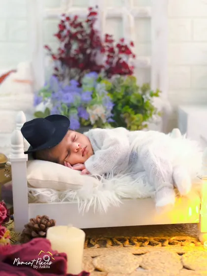 Dreaming big from his tiny bed. This creative newborn setup with a miniature bed and a little hat is a whimsical way to capture this fleeting stage.
