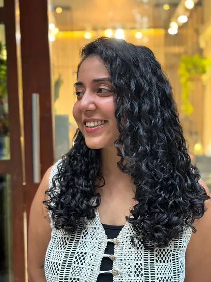 I had so much fun styling this real-life Moana. Her beautiful, long curls are accessorized with flowers and clips, showing how versatile curly hair can be.