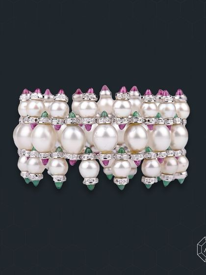This three-line South Sea pearl bracelet with diamonds, rubies, and emeralds is a statement piece that fulfills the desire for true luxury.