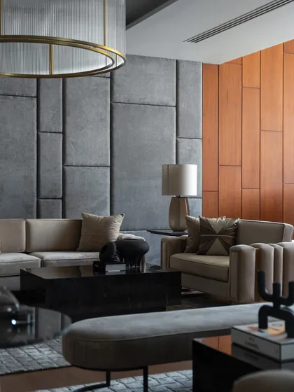 This contemporary living space embodies sleek lines and a seamless blend of comfort and style, featuring a custom upholstered wall that adds texture and acoustic comfort.
