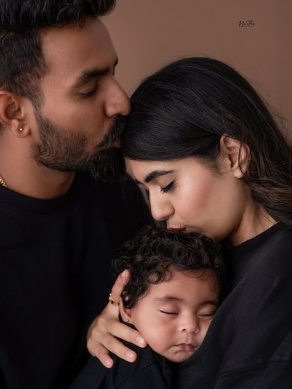 A powerful and intimate family portrait. The all-black outfits create a dramatic and unified look, focusing on the deep connection and love within the family.