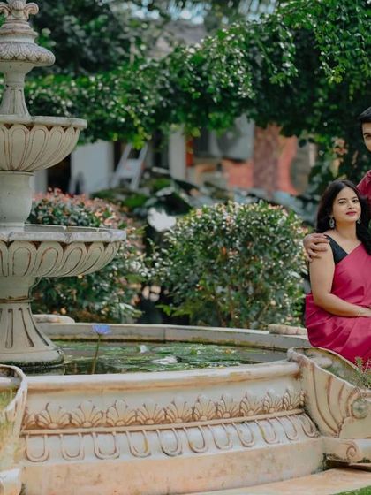 A classic portrait by the white fountain in our garden, a serene and elegant setting.