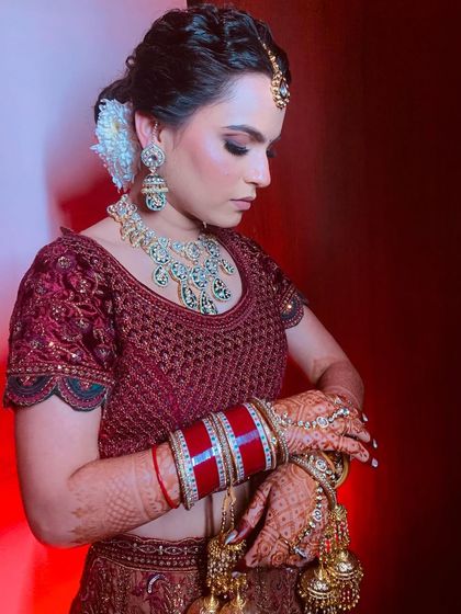 A candid shot showing the details of her jewelry and the beautiful texture of her messy bridal bun.