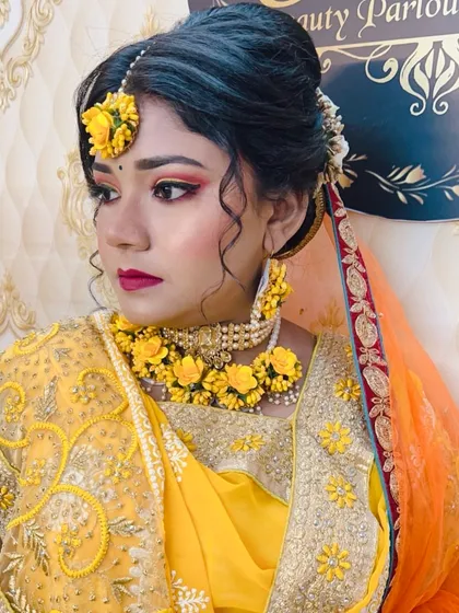 A close-up of a Haldi bride, showing the intricate floral jewelry and the fresh, glowing makeup. The eye makeup has hints of yellow and orange to match the theme.