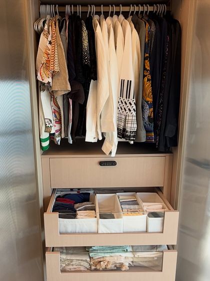 This closet section shows how we combine hanging space with drawer organization. The top drawer uses dividers for small items like socks and accessories, while the glass-front drawer below holds neatly folded clothes.