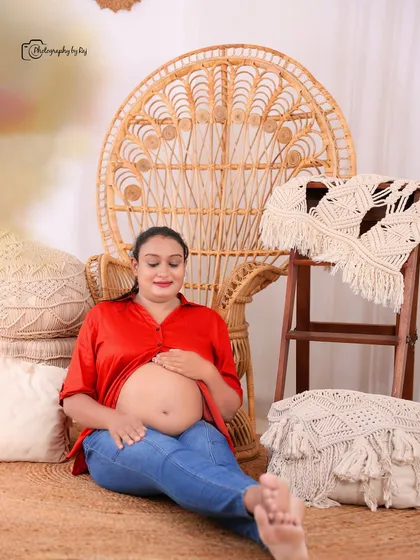 A relaxed bare-bump portrait in our bohemian-themed studio setup, featuring a peacock chair and macrame details.