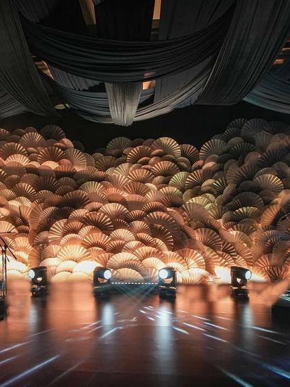 The 'Fanning the Flames of Love' stage backdrop at 'Midnight Mirage'. This mesmerizing installation was crafted from thousands of intricately folded paper fans, dancing together in harmony.