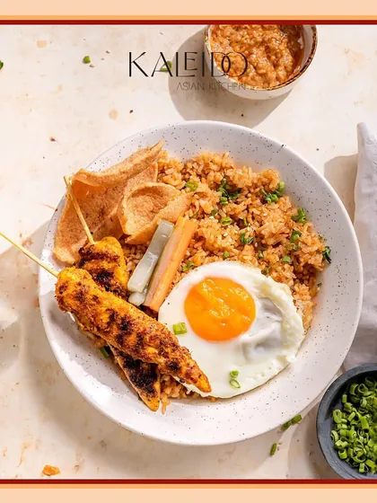 My take on the classic Nasi Goreng. This Indonesian fried rice is a complete meal, packed with flavor and served with chicken satay, a fried egg, and crispy crackers for that perfect texture.