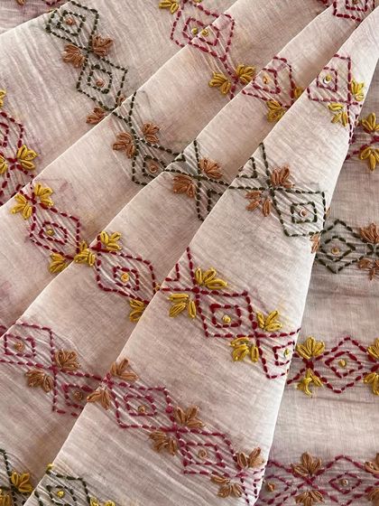This hand-embroidered Mul Chanderi features a unique geometric pattern in multi-colored threads. It's a beautiful blend of traditional craft and contemporary design.