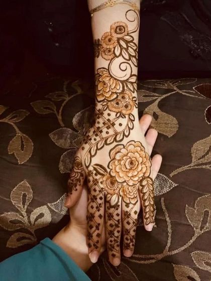 A beautiful floral vine that trails gracefully up the arm, with delicate net details on the fingers.