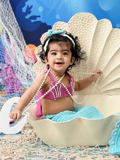 The most adorable little mermaid in the sea. With a sparkling tail and a seashell to sit in, this underwater-themed photoshoot is a whimsical way to celebrate a milestone.