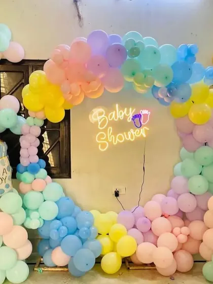 A close-up of a pastel rainbow "Baby Shower" balloon arch. This image highlights the beautiful blend of colors and the "It's a Boy" and "It's a Girl" foil balloons, perfect for a gender-neutral shower or reveal.