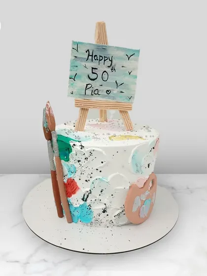 A creative cake for Pia's 50th birthday, designed for an artist with a paint palette, brushes, and a mini easel.