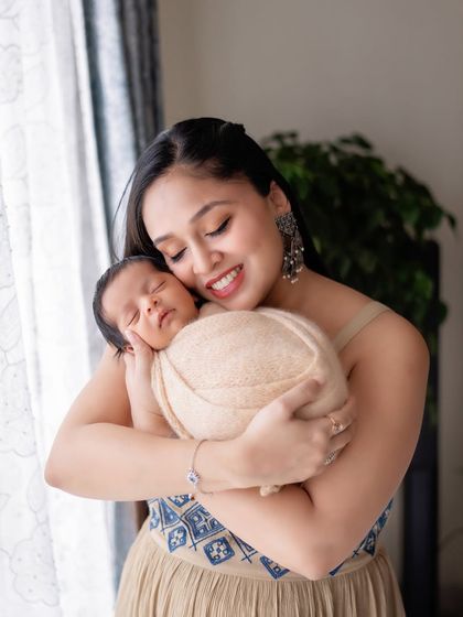 A new mother's joy. This portrait captures the beautiful bond between a mom and her sleeping newborn.