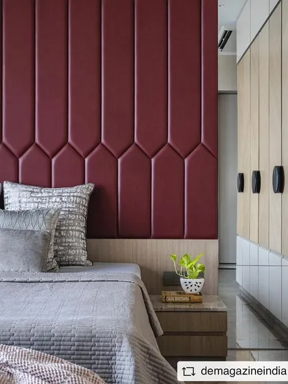 A bedroom in the 'Aria Residence' featuring a bold red upholstered headboard and custom wardrobes. The design is a perfect example of contemporary elegance.