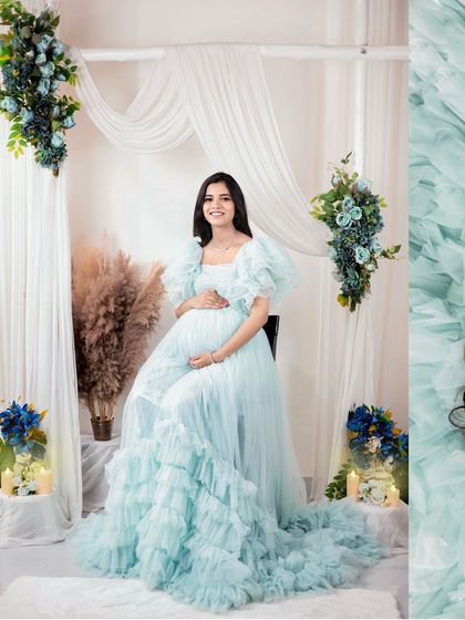 A serene and elegant portrait in a light blue ruffled gown. This setup, with soft white drapes and floral accents, creates a dreamy and peaceful atmosphere.